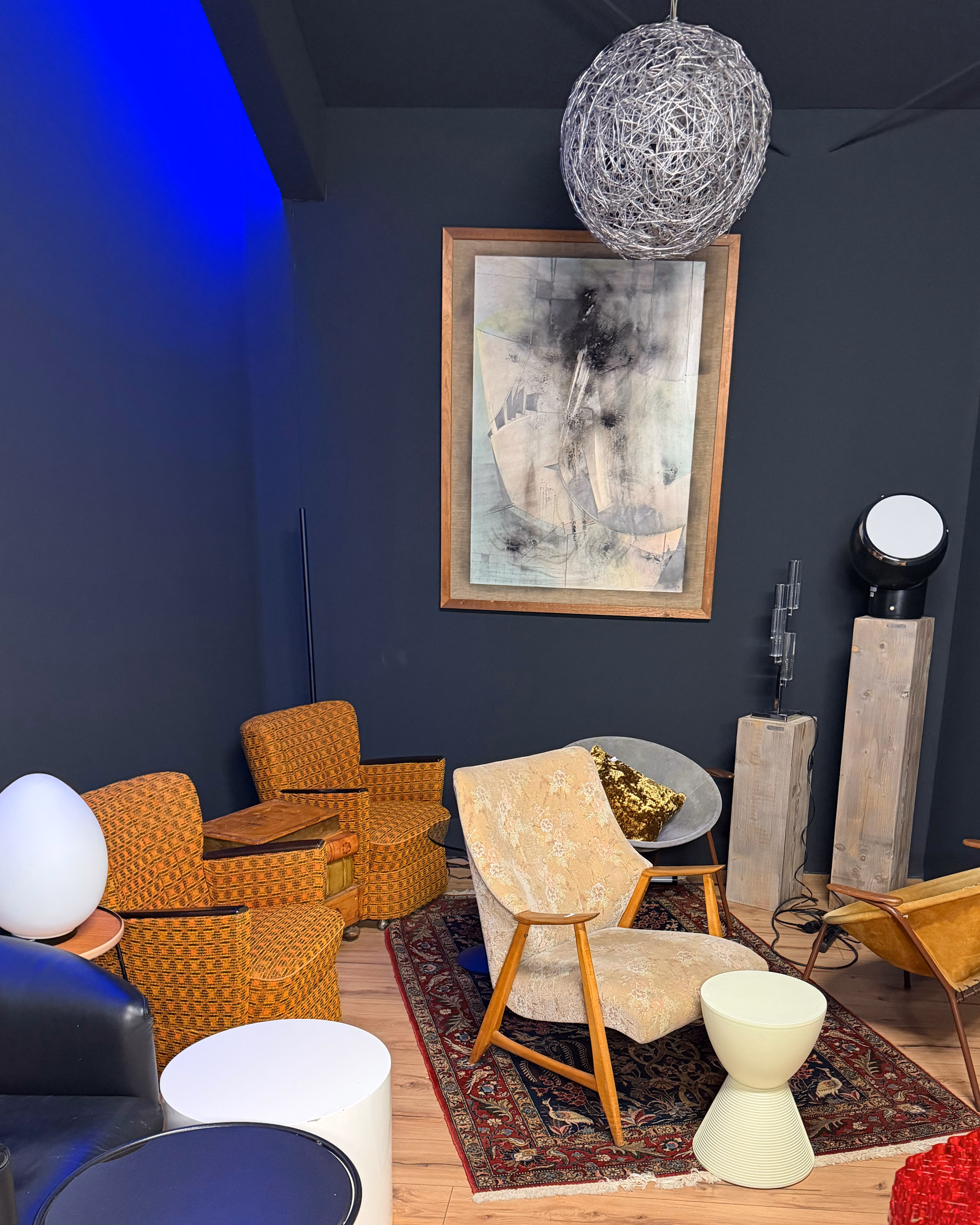 Lounge-Ecke im Design Studio mit Cocktailsesseln, Perserteppich und abstraktem Gemälde